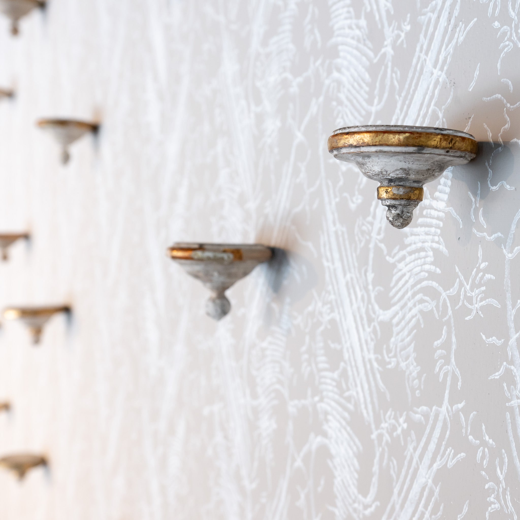 COLLECTION OF SIXTEEN 18TH-CENTURY ANTIQUE WALL BRACKETS WITH PAPER FLOWERS ON HAND TURNED WOOD BASES