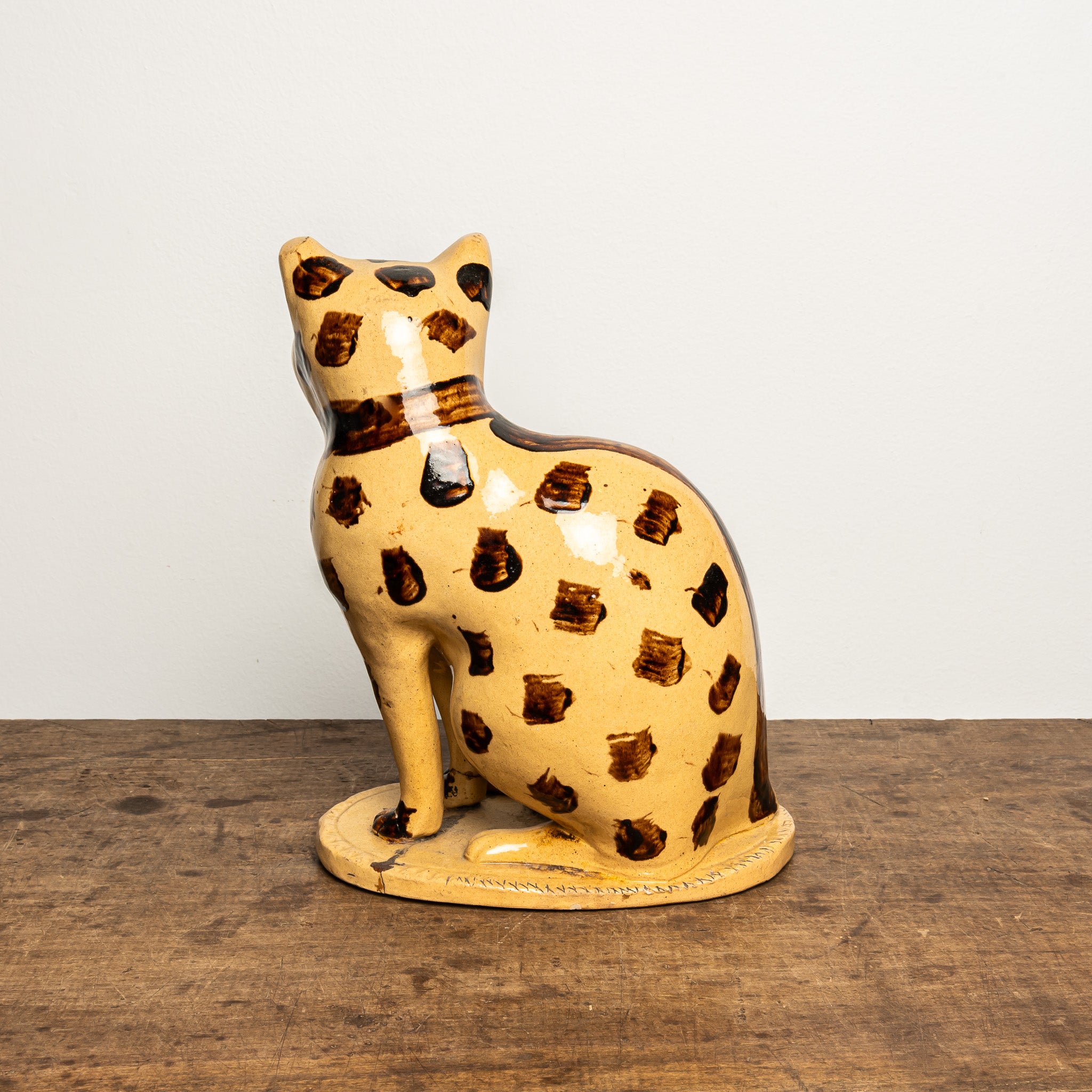 LATE 19TH-CENTURY ENGLISH STAFFORDSHIRE-STYLE GLAZED EARTHENWARE LEOPARD CAT FIGURE