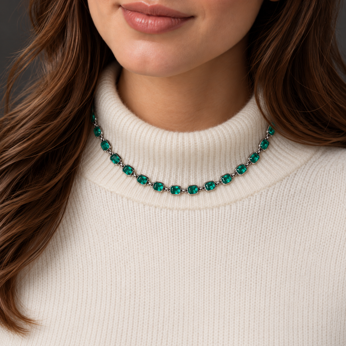 AI styling illustration of the 17 inch Georgian emerald paste rivière necklace worn over ivory cashmere; scale approximate