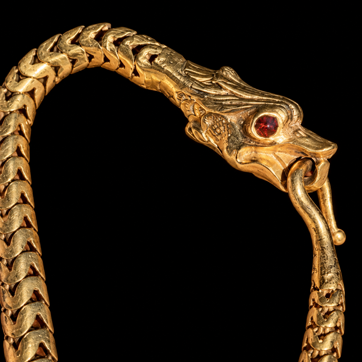 Detail of carved snake head, garnet eye and hook clasp