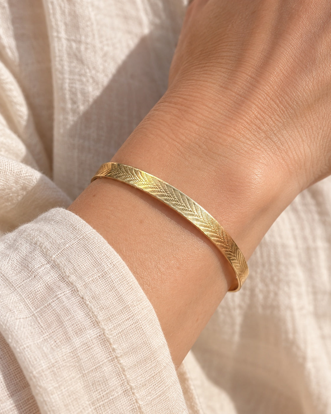 EARLY 20TH CENTURY HERRINGBONE 9 KARAT GOLD CASED BANGLE — worn view