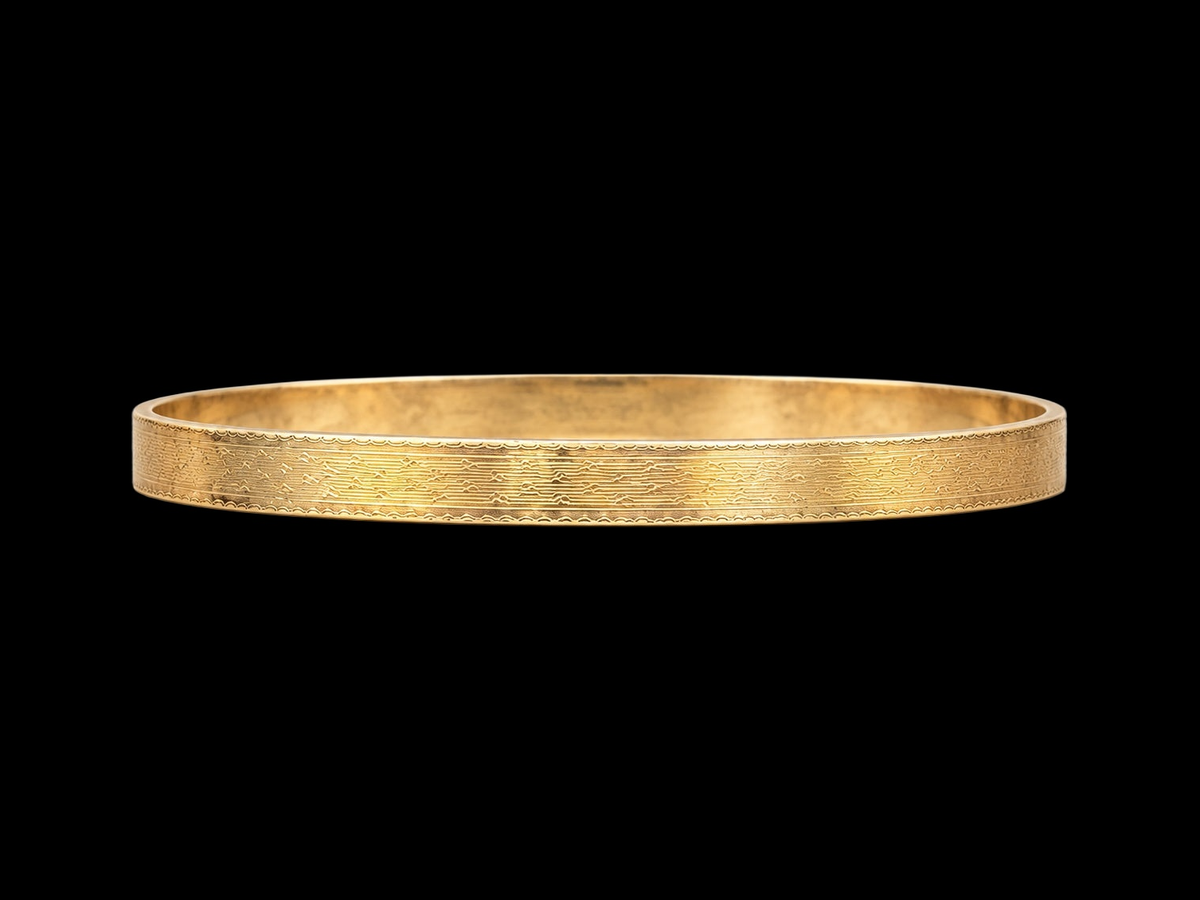 EARLY 20TH CENTURY STEPPED WAVE 9 KARAT GOLD CASED BANGLE on black background
