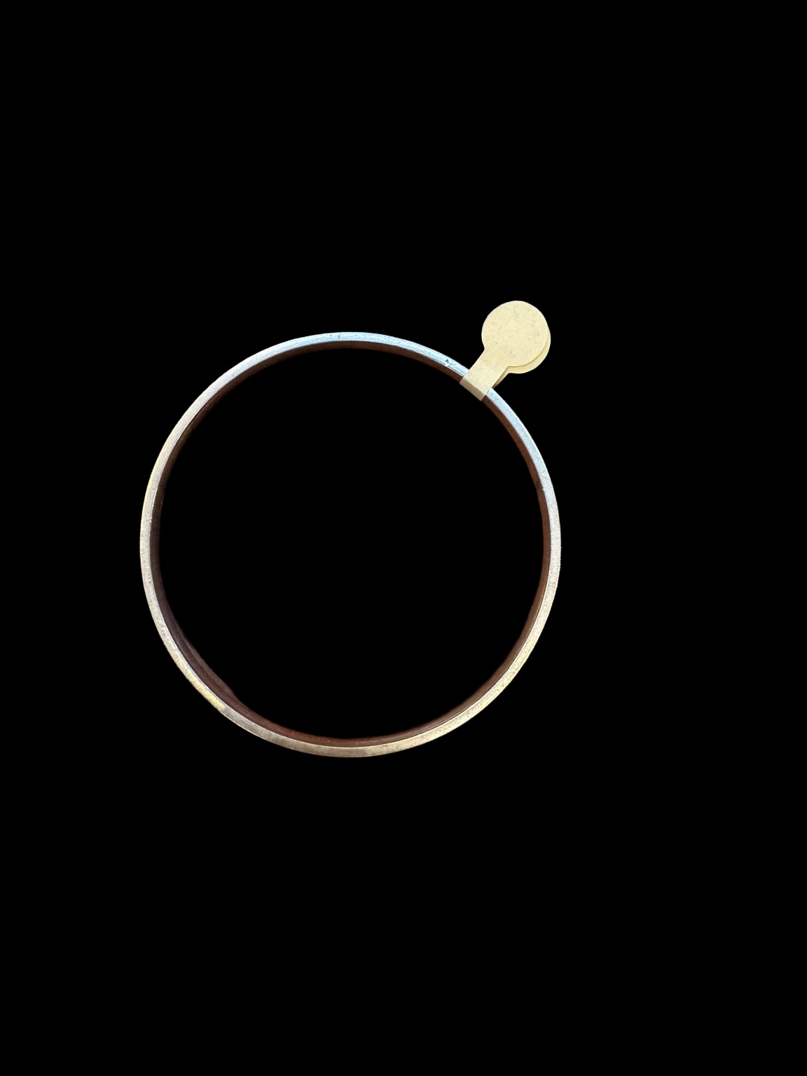 EARLY 20TH CENTURY SCROLL 9 KARAT GOLD CASED BANGLE on black background