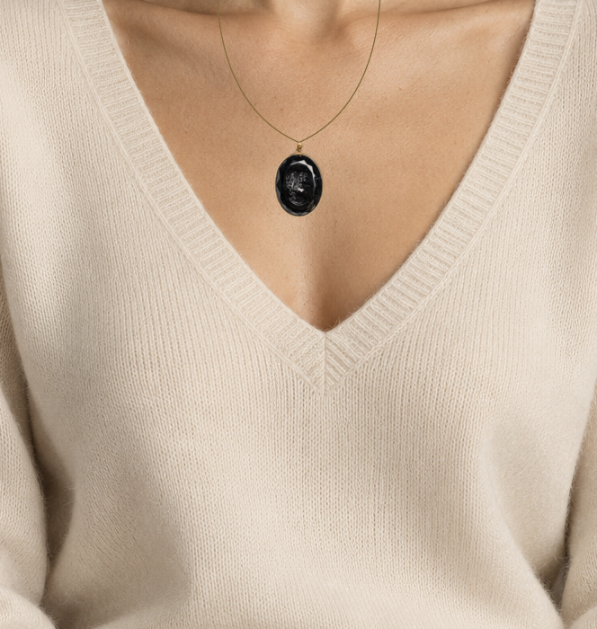 Illustrative close wearing detail of 19th century french jet glass cameo pendant in 18k gold. Original photographed jewelry preserved; scale approximate.
