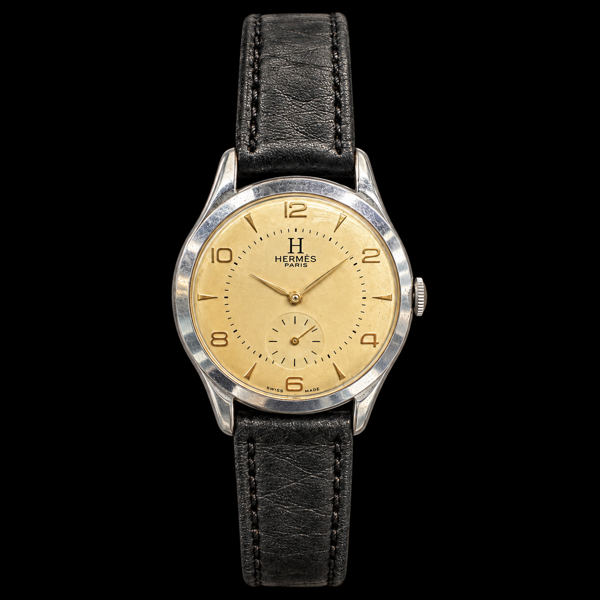 VINTAGE WATCH WITH HERMÈS SIGNED CHAMPAGNE DIAL ON BLACK BACKGROUND