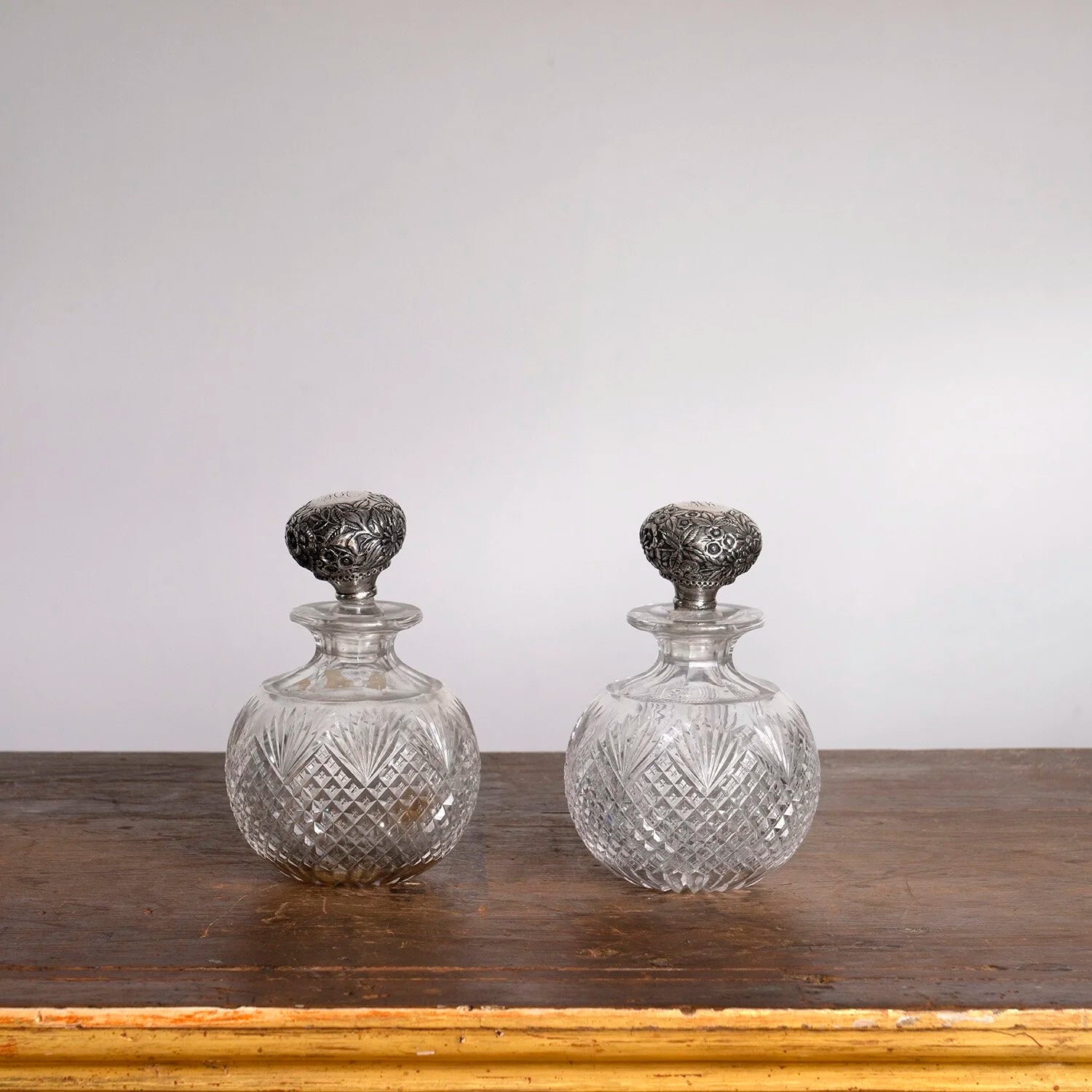 PAIR OF ENGLISH EDWARDIAN SILVER TOPPED PERFUME BOTTLES