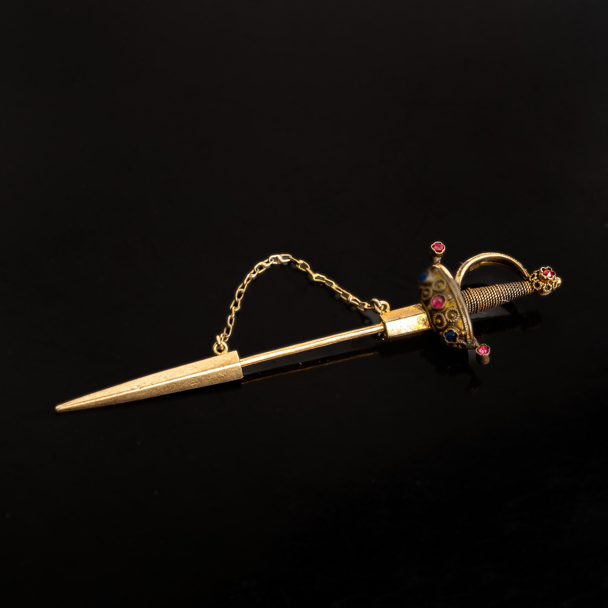 LATE 19TH-CENTURY GOLD SWORD JABOT PIN WITH RUBY AND SAPPHIRE ACCENTS