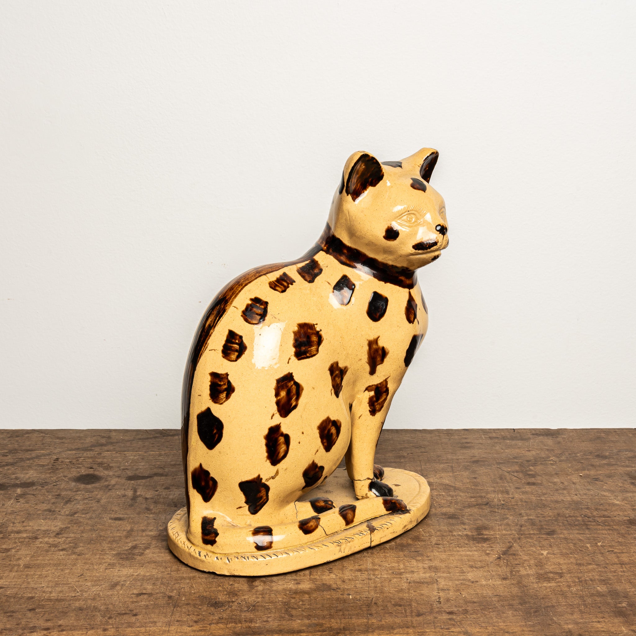 LATE 19TH-CENTURY ENGLISH STAFFORDSHIRE-STYLE GLAZED EARTHENWARE LEOPARD CAT FIGURE