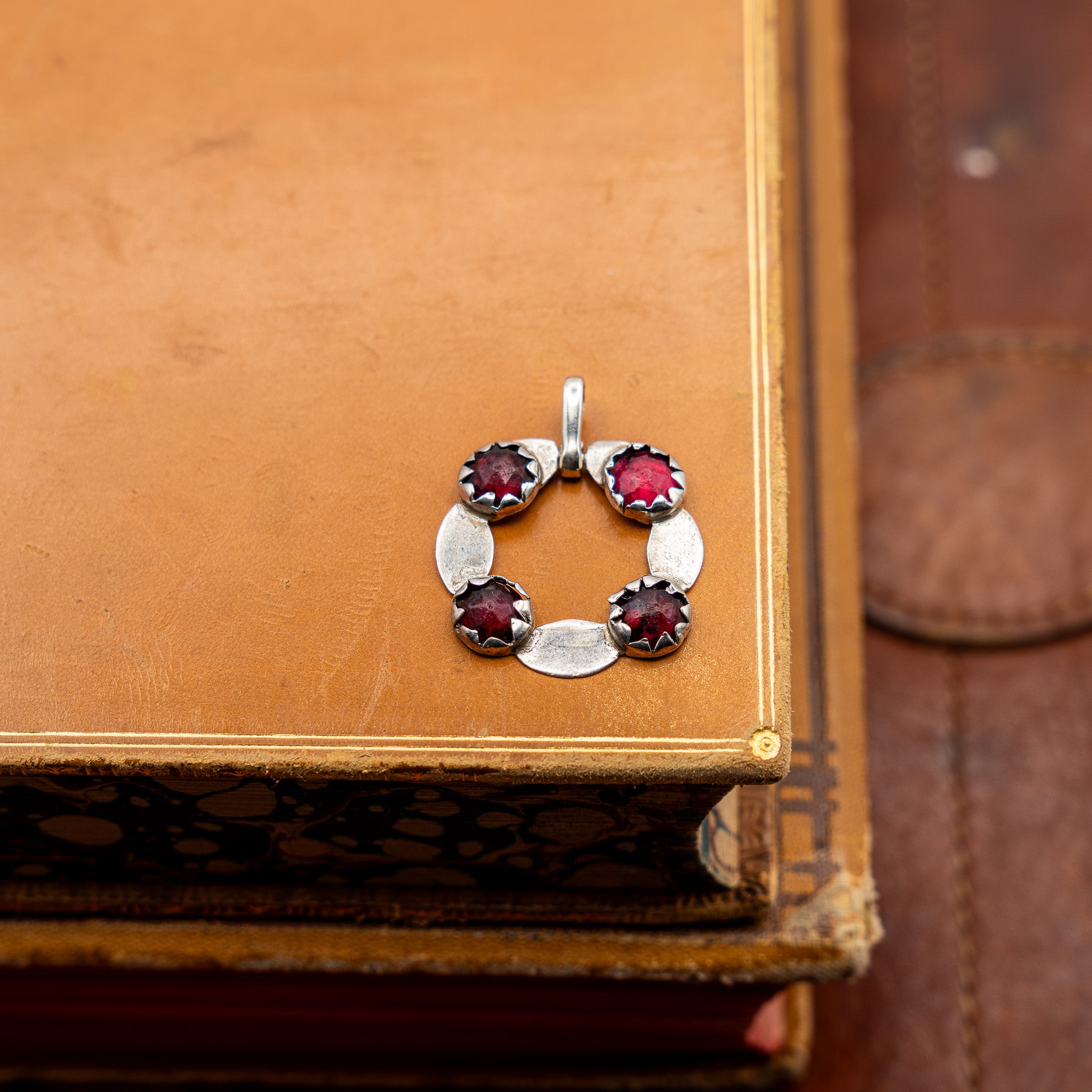 GEORGIAN ENGLISH SILVER AND FOIL-BACKED GARNET PENDANT, CONVERTED FROM A BUCKLE