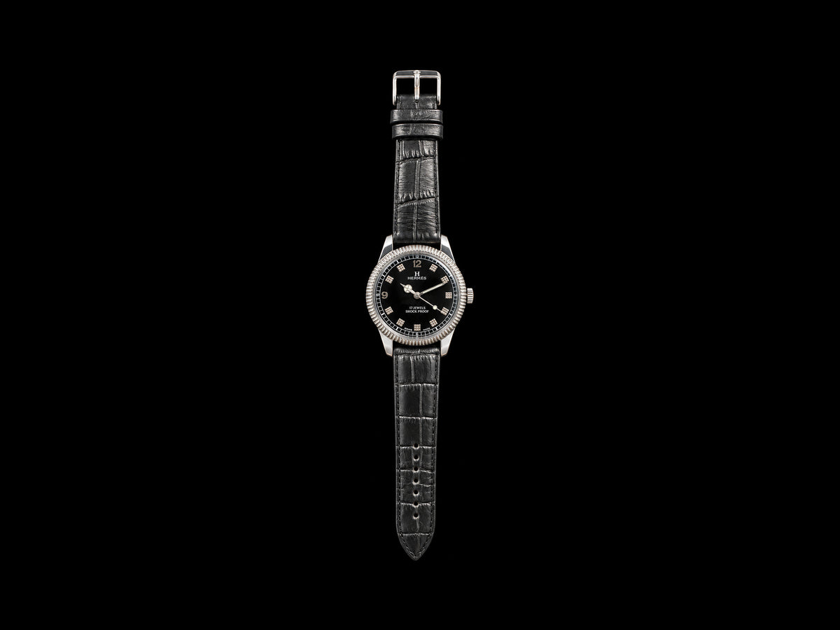 VINTAGE WATCH WITH HERMÈS SIGNED BLACK DIAL AND TEXTURED MARKERS — front view