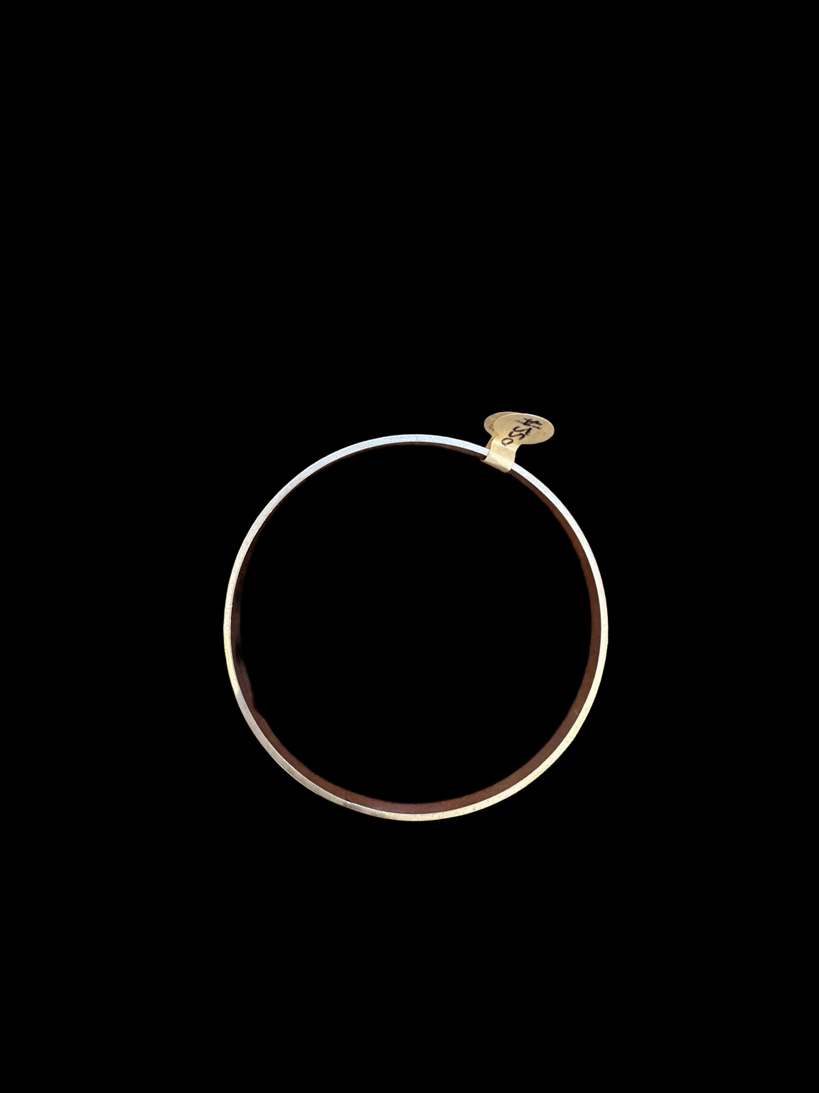 EARLY 20TH CENTURY STEPPED WAVE 9 KARAT GOLD CASED BANGLE on black background