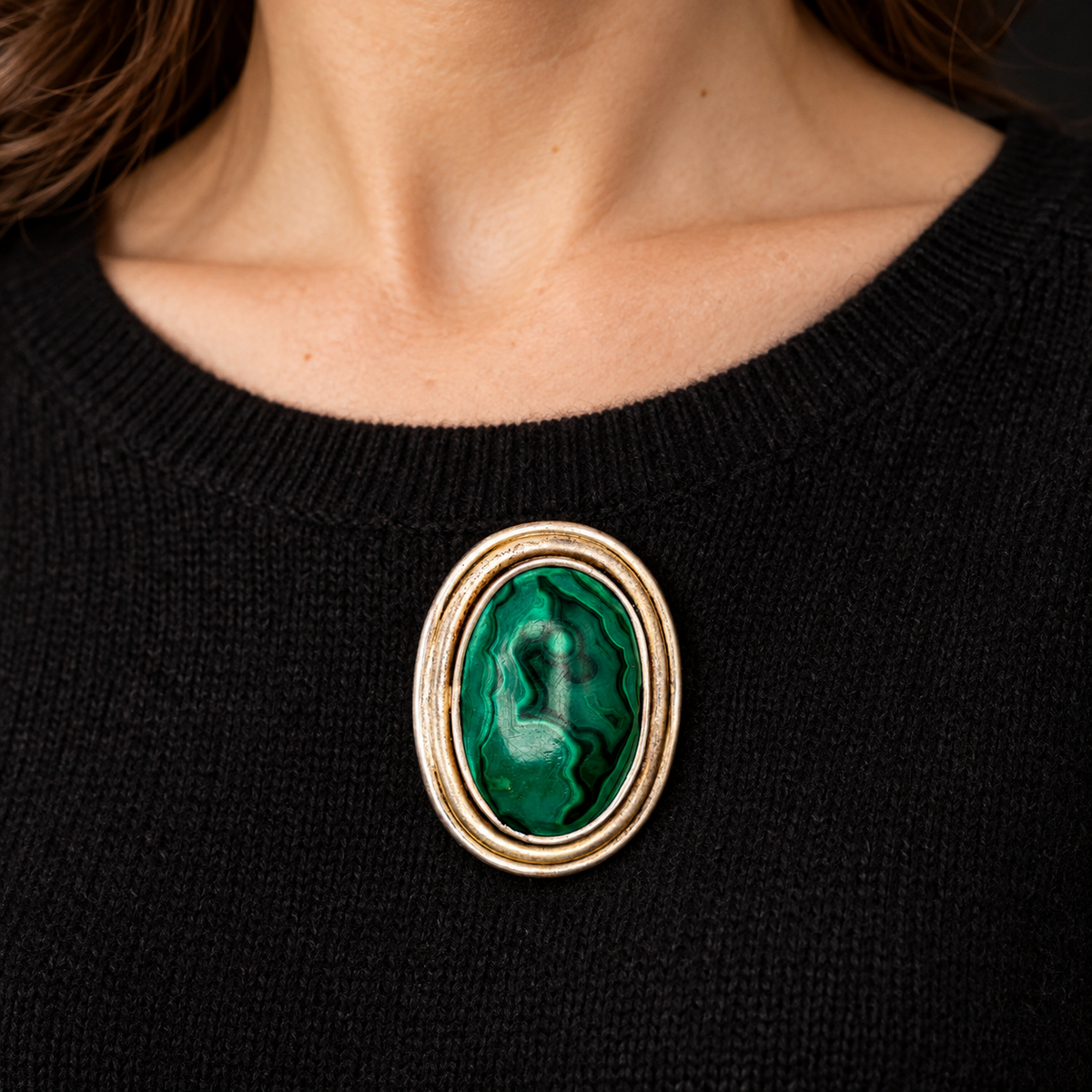 Illustrative wearing view of MALACHITE AND PINCHBECK BROOCH WORN ON BLACK CASHMERE. SCALE IS APPROXIMATE.